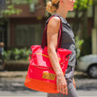 Tote Bag Allcatrazes Allca x Brasco Coral Esquina em tecido hidrorrepelente usada no ombro por modelo na rua - foto lifestyle urbana