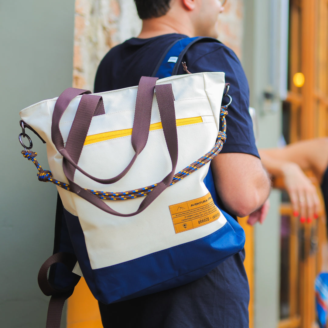 Tote Bag Allcatrazes Allca x Brasco Off White Encontro em tecido hidrorrepelente usada como mochila nas costas - foto lifestyle do modo aventura urbana
