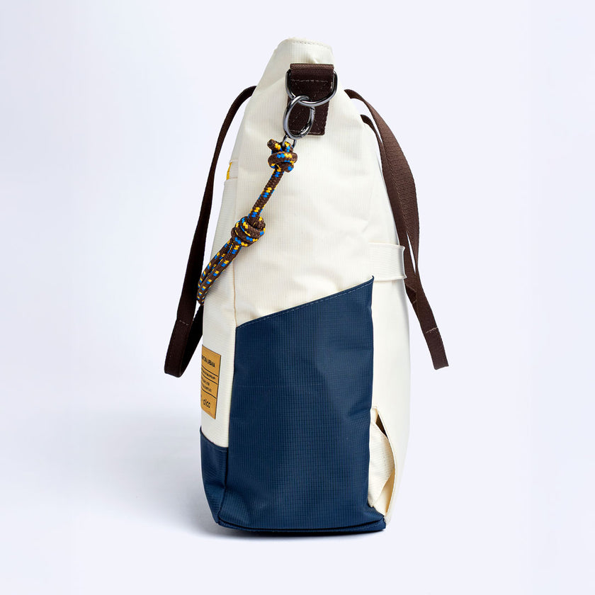 Tote Bag Allcatrazes Allca x Brasco Off White Encontro com base azul marinho em tecido hidrorrepelente, 16L - vista de perfil mostrando a profundidade de 13 cm