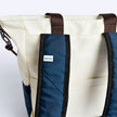 Tote Bag Allcatrazes Allca x Brasco Off White Encontro em tecido hidrorrepelente - detalhe das alças mochila azul marinho e etiqueta allca