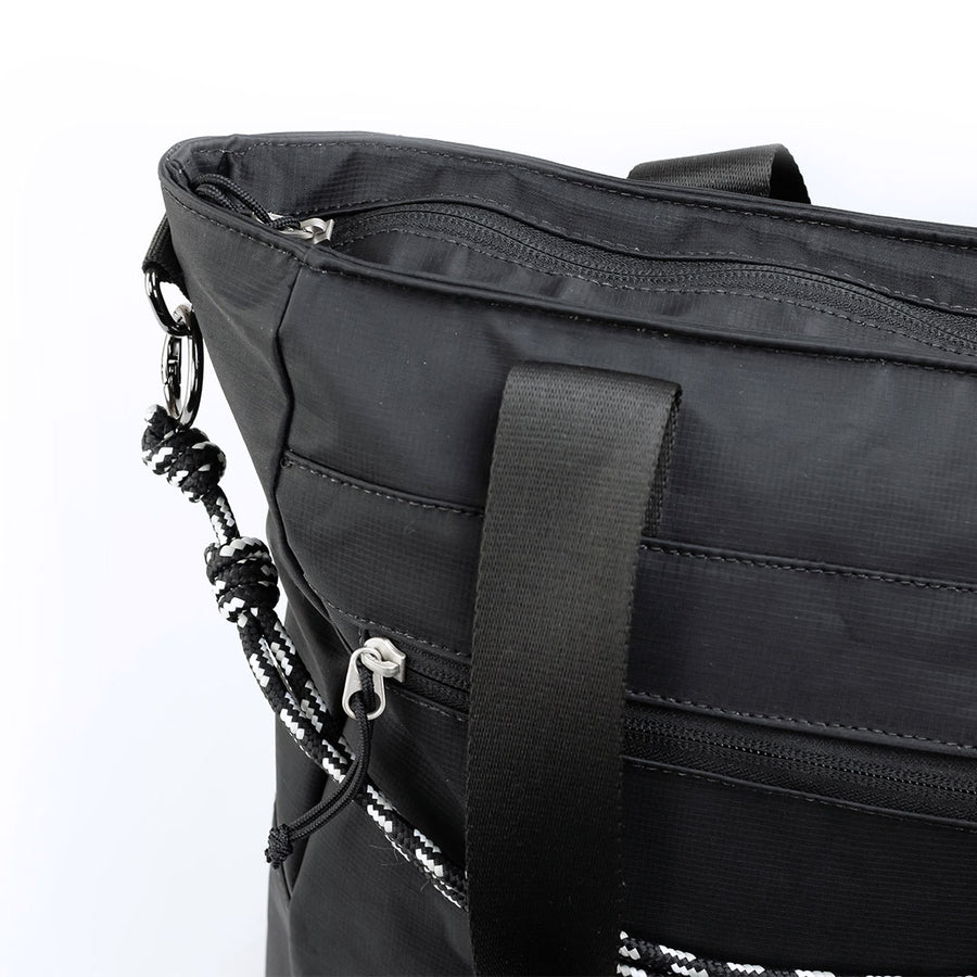 Tote Bag Eclipse Allca Allcatrazes preta em tecido hidrorrepelente - detalhe do ziper, da alca e da tira ajustavel em cabo nautico preto e branco